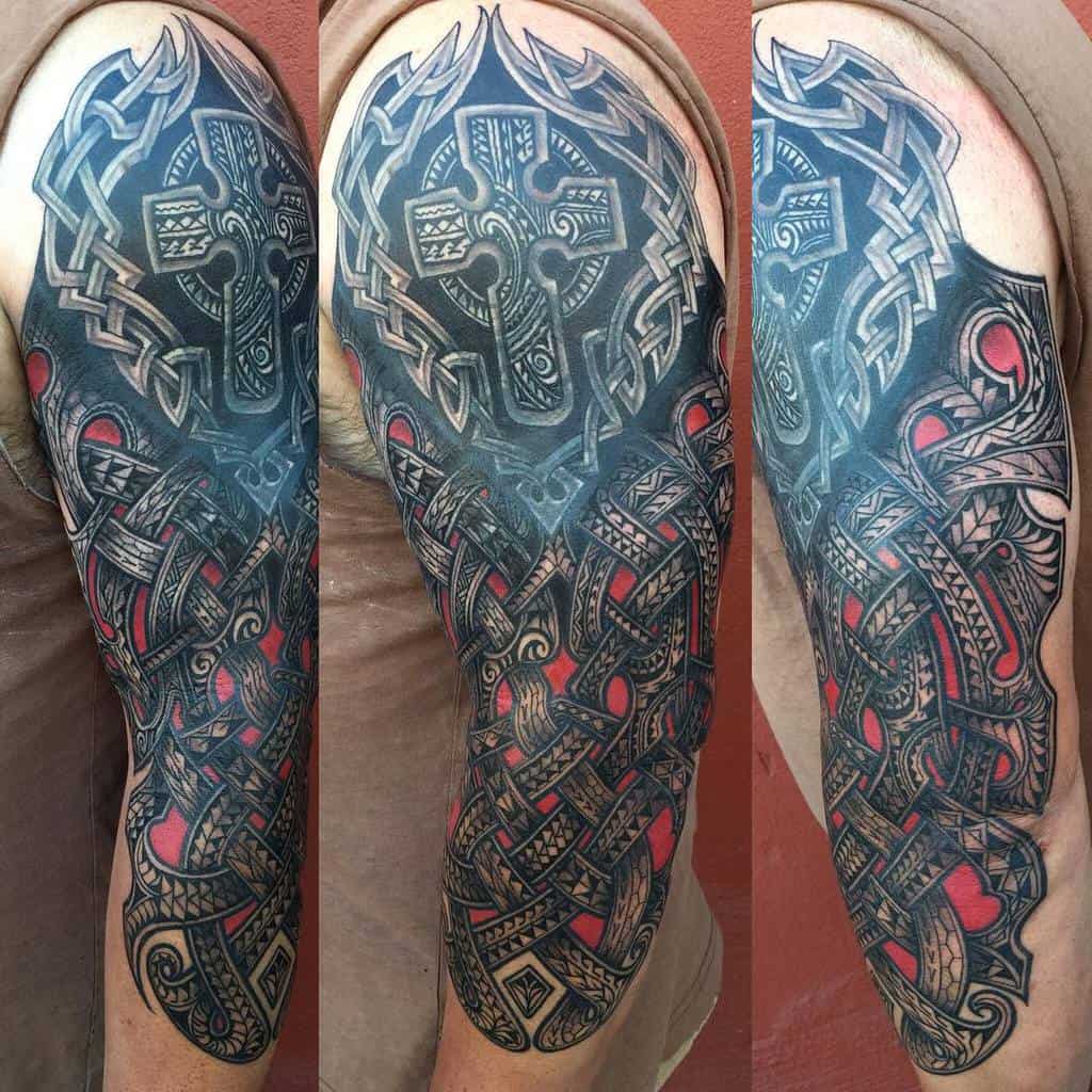 Arm tattoo with intricate Celtic knotwork, featuring a large cross and red accents, covering the shoulder to the elbow
