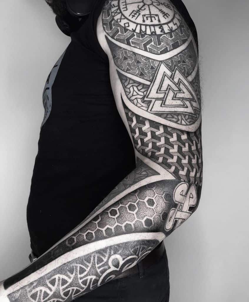 A full-sleeve tattoo featuring intricate Nordic and Celtic knotwork, the Vegvisir symbol, Valknut, and detailed geometric patterns