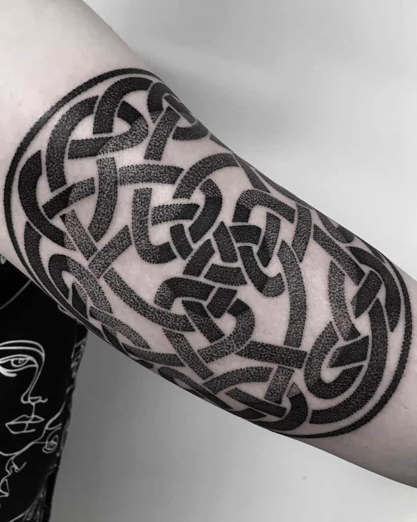 Celtic knot tattoo with intricate black patterns on upper arm
