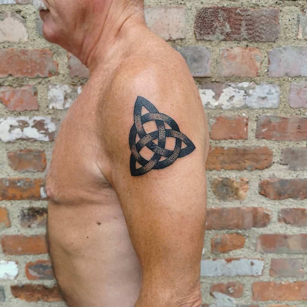 A man with a Celtic knot tattoo on his upper arm