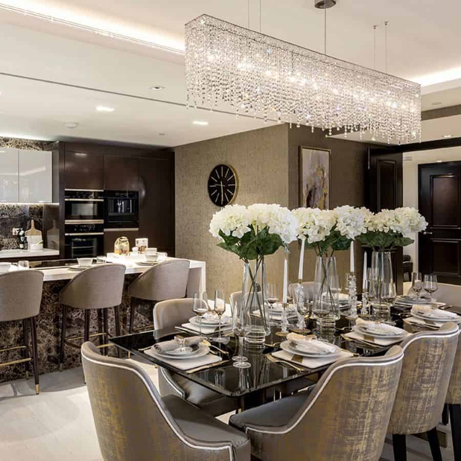 open kitchen dining room dining table and chairs flowers in vases long narrow glass chandelier