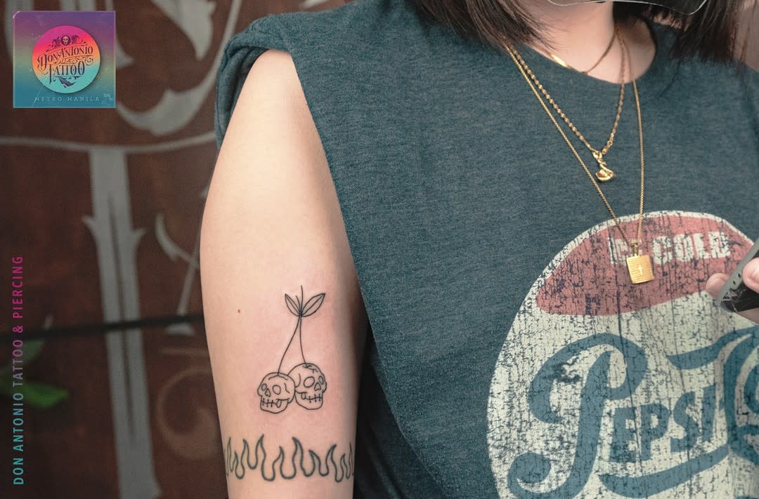 Cherry skull tattoo on arm