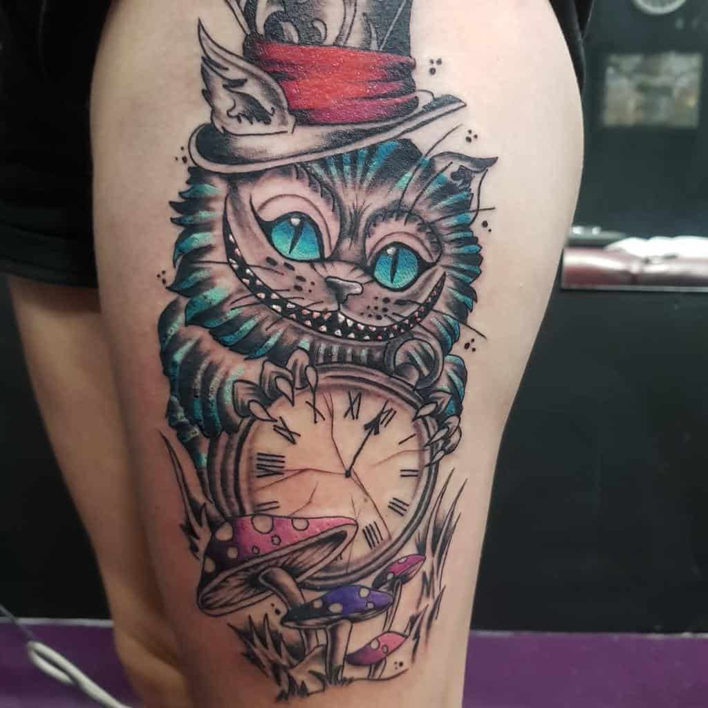 Vibrant tattoo of the Cheshire Cat from Alice in Wonderland, wearing a top hat and holding a clock, surrounded by colorful mushrooms
