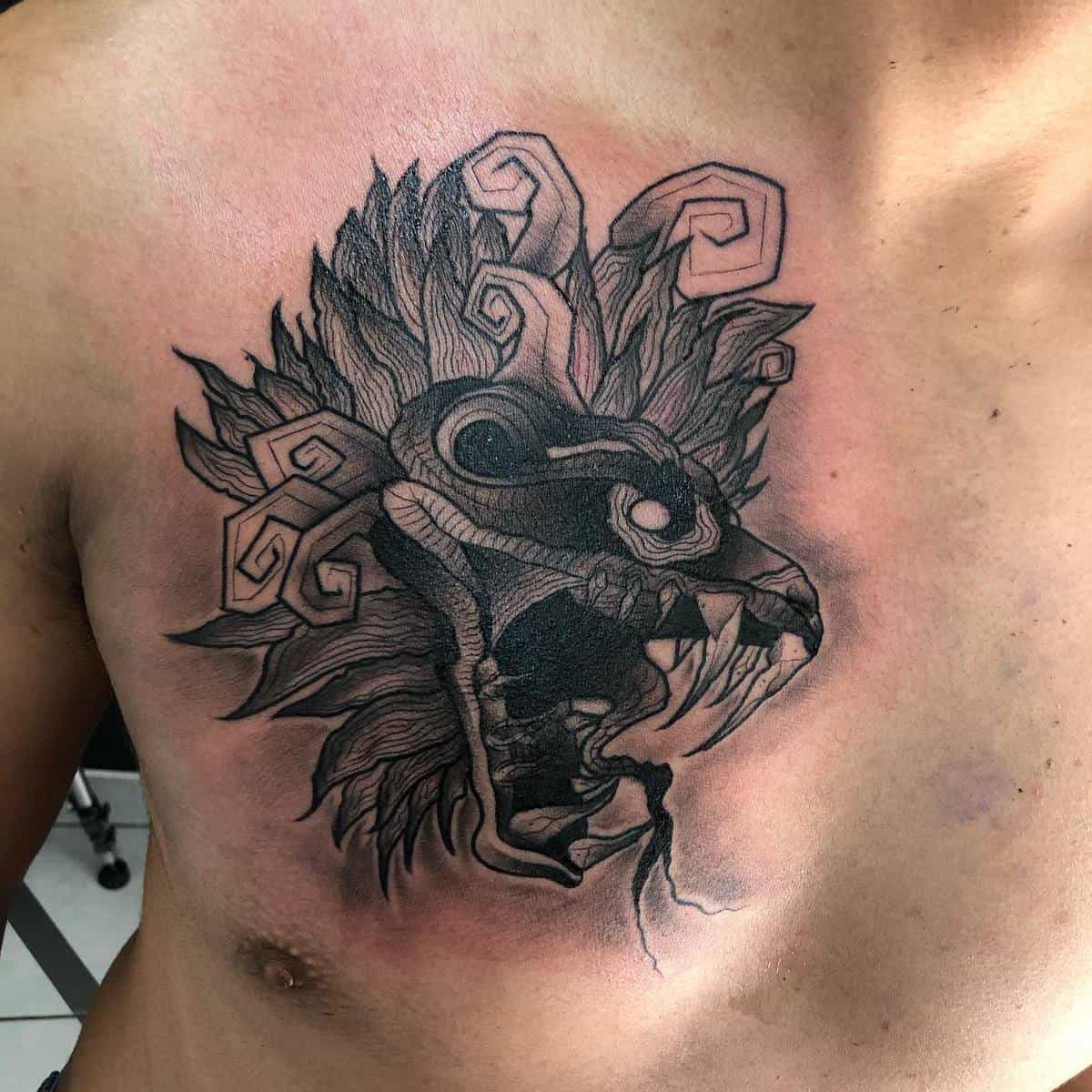 Bold chest tattoo of Quetzalcoatl featuring a detailed feathered serpent with fierce expression