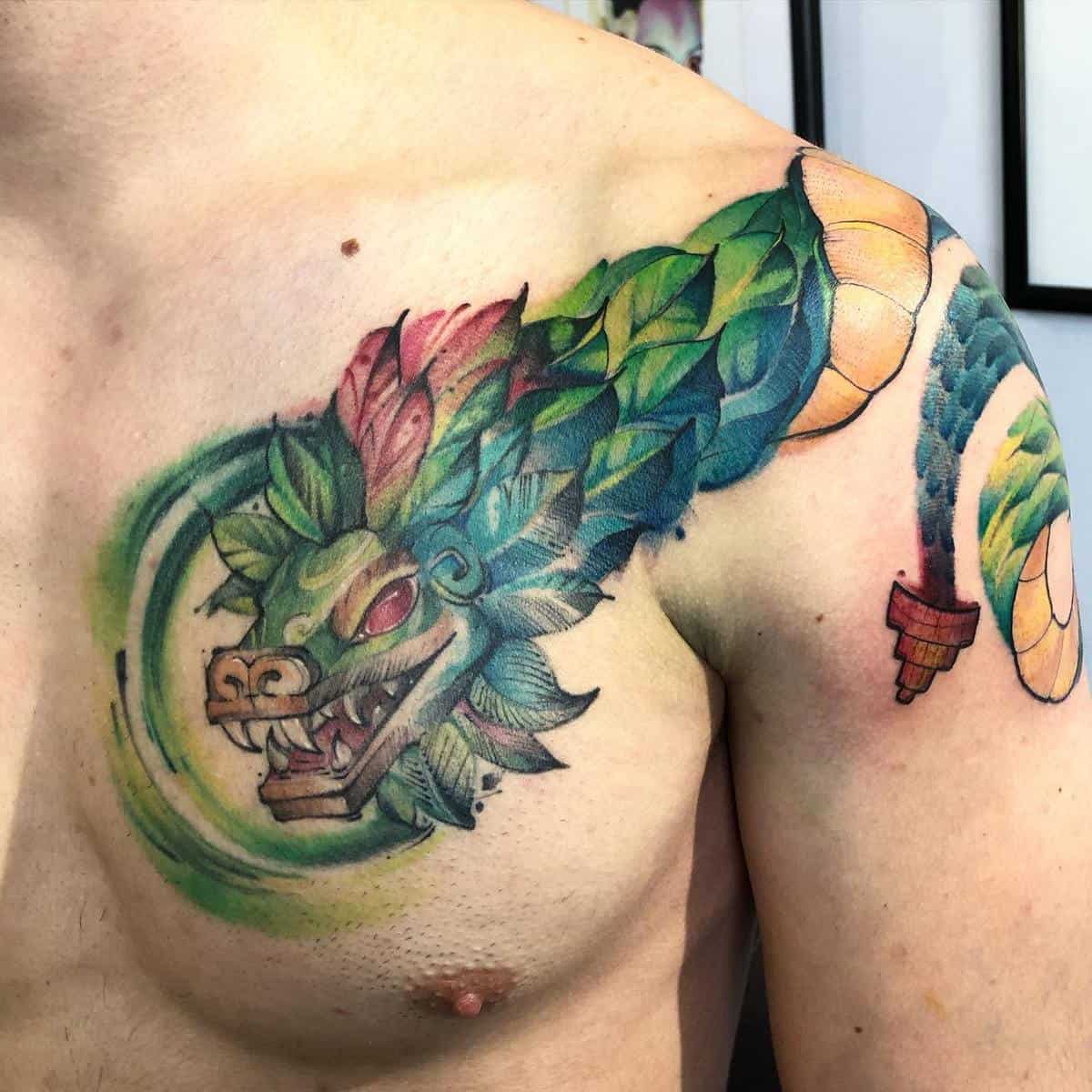 Colorful Quetzalcoatl tattoo featuring a vibrant feathered serpent head and body wrapping around the shoulder