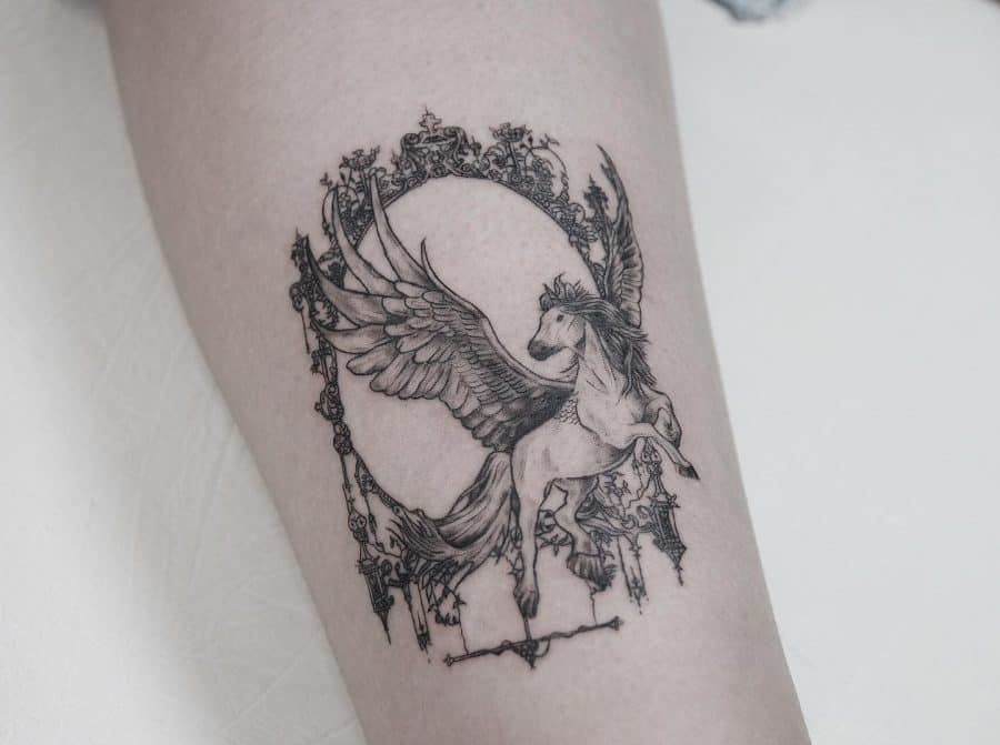 Intricate black ink tattoo of a winged unicorn, framed by an ornate circular design, blending fantasy and gothic elegance.