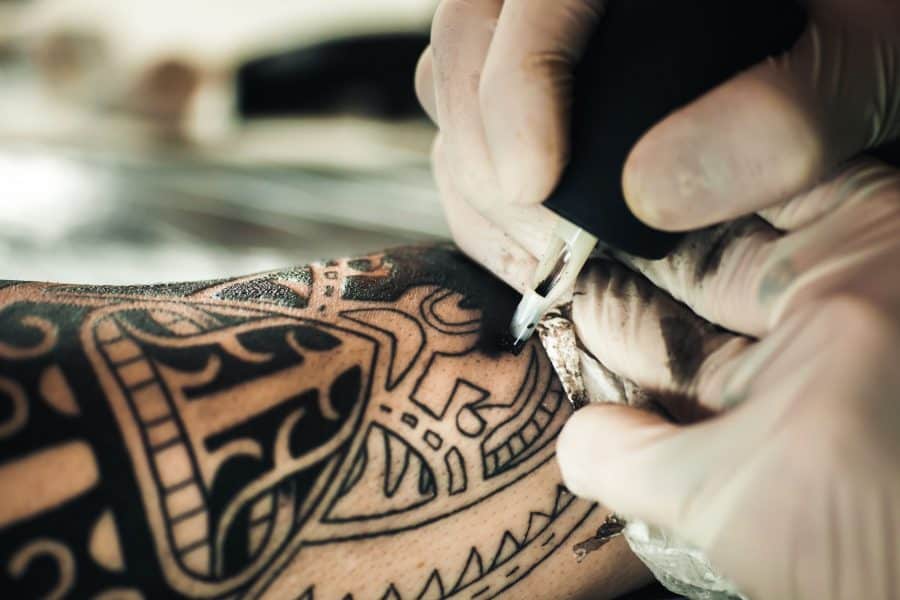A person receiving a forearm tattoo from a skilled artist using single needle technique