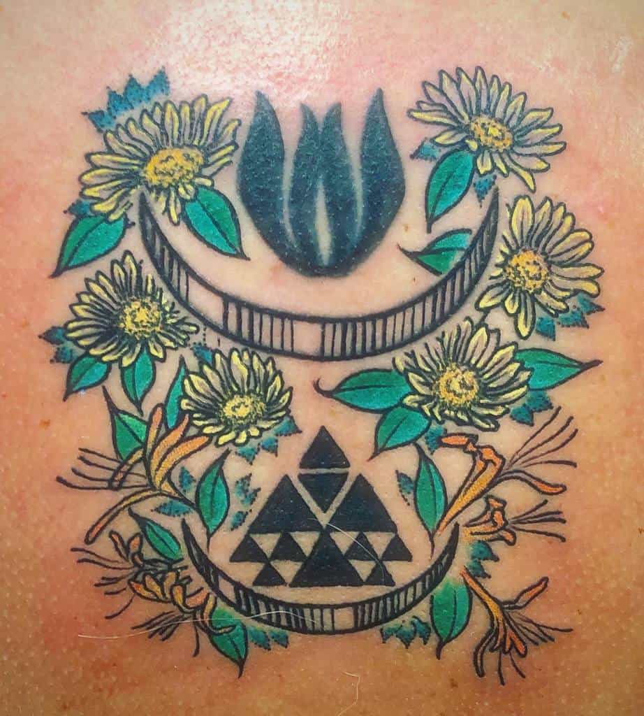 Colorful geometric tattoo with honeysuckle and daisies surrounding a crescent moon and triangles