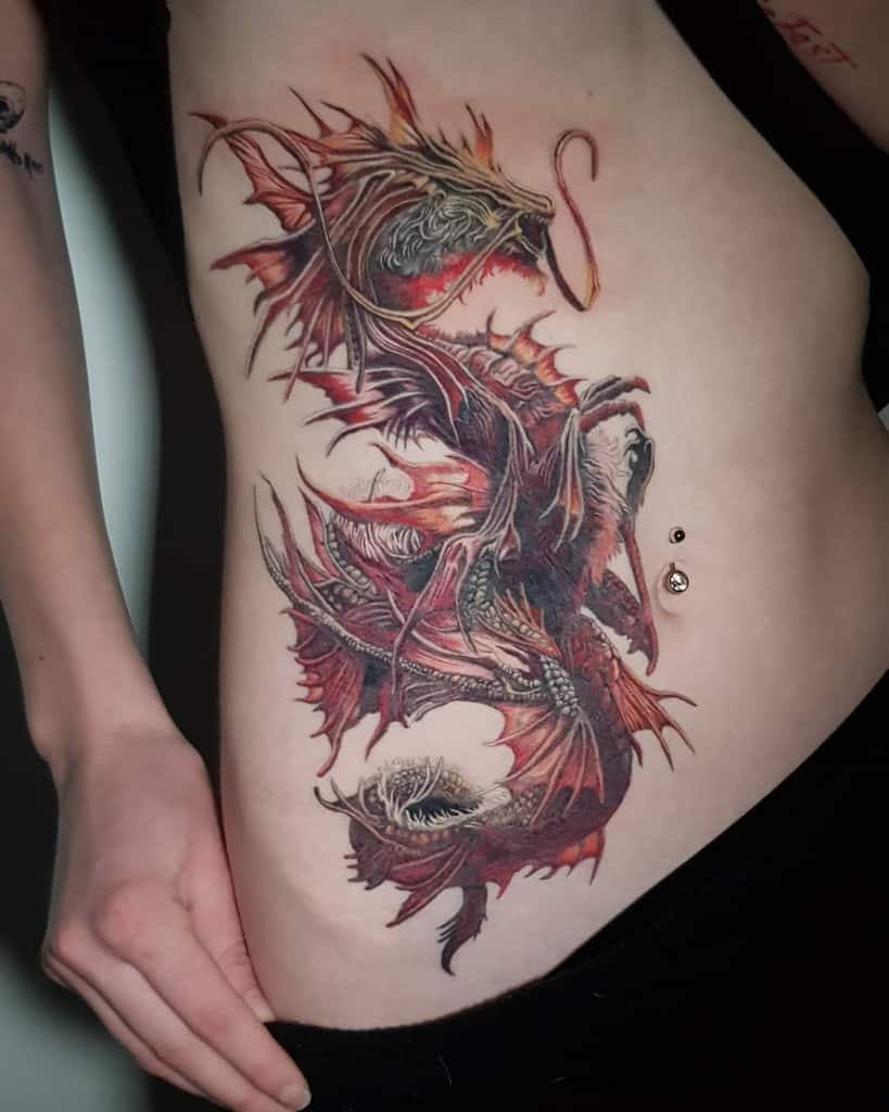 Dragon tattoo on a woman's side with detailed, colorful design