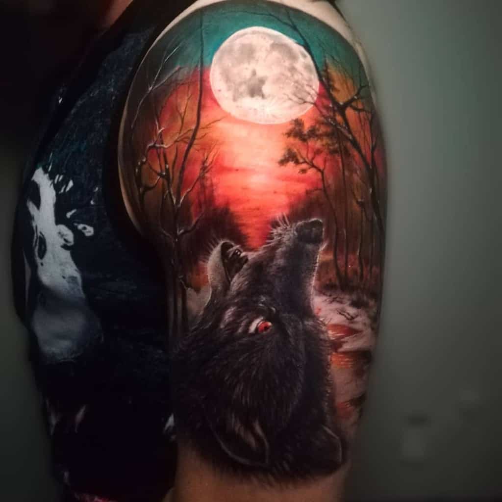 Tattoo of a wolf howling at the moon set against a forest and colorful sky