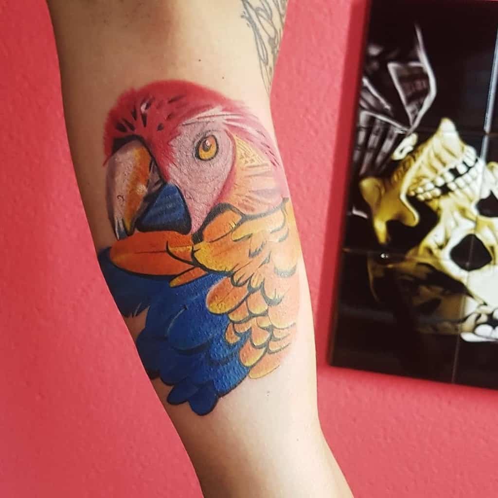 Colorful parrot tattoo on an arm 