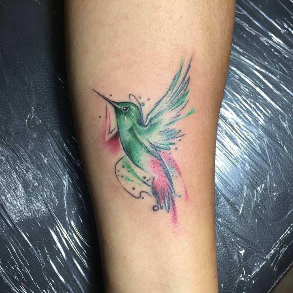 A colorful hummingbird tattoo on a forearm