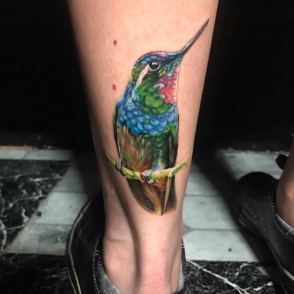 A colorful hummingbird tattoo on a  leg