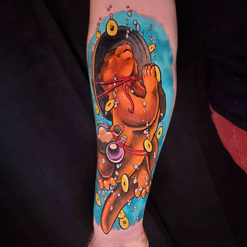 Colorful otter tattoo on a forearm, with an otter playfully floating amidst bubbles and vibrant orange discs against a blue-black backdrop