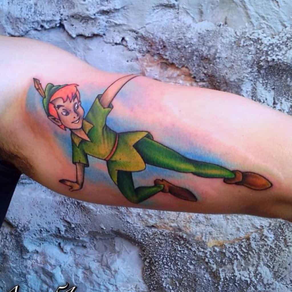 A dynamic full-color tattoo of a lively character in green attire, mid-flight with outstretched arms, detailed shading, and vibrant tones