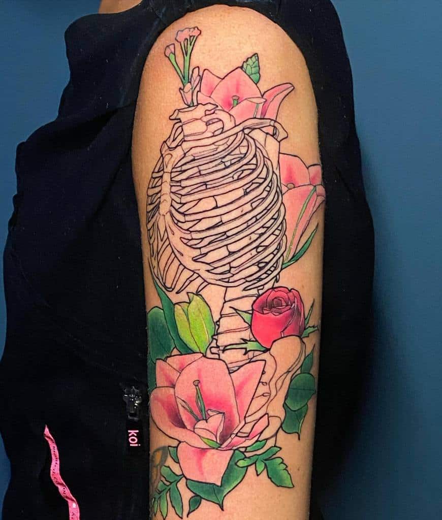 Arm tattoo of a ribcage with pink and green flowers