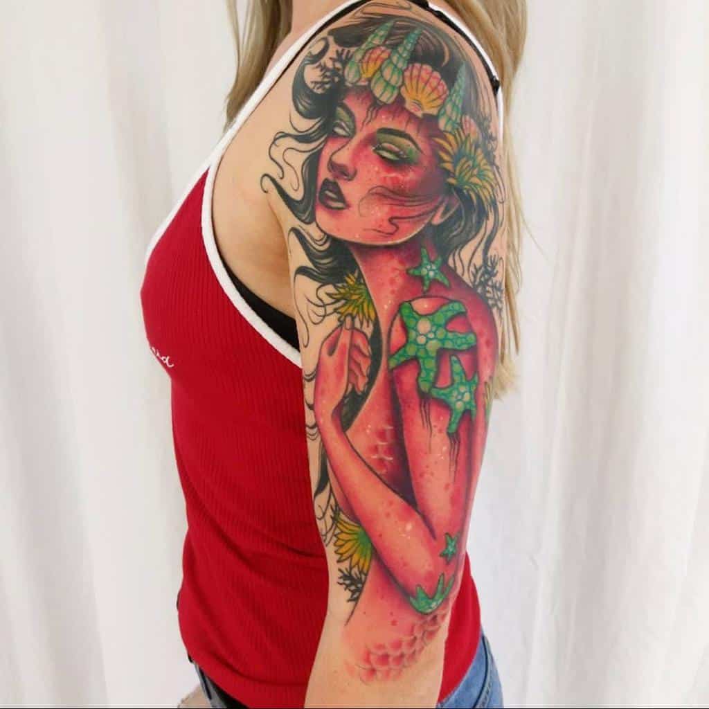 Woman with a colorful tattoo of a mythical figure on her arm