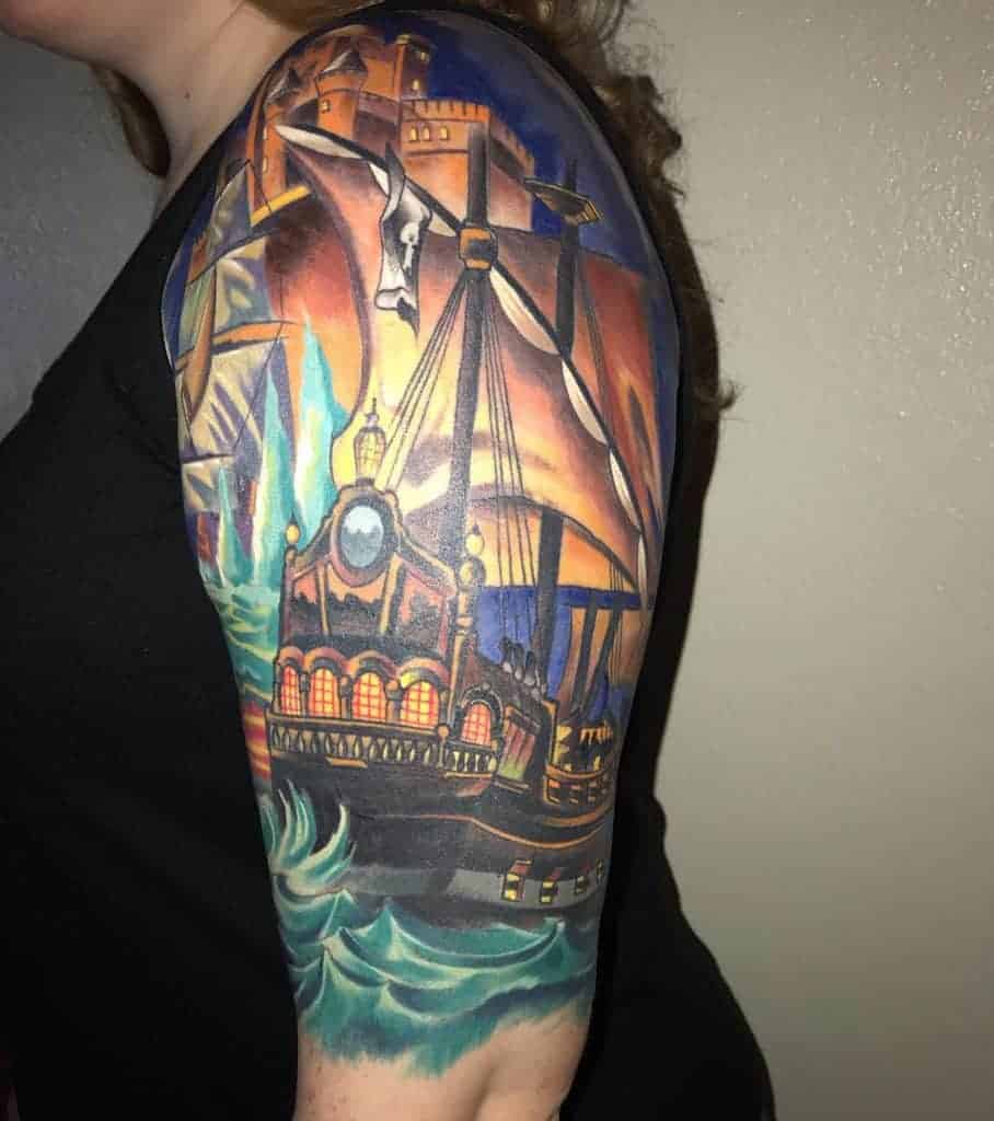 Colorful ship and castle tattoo on a woman's upper arm