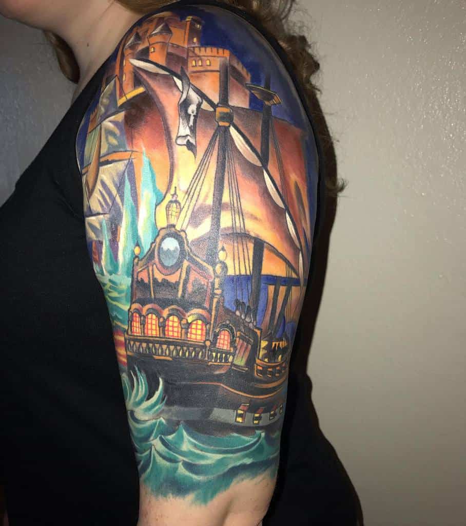 Colorful ship and castle tattoo on a woman's upper arm