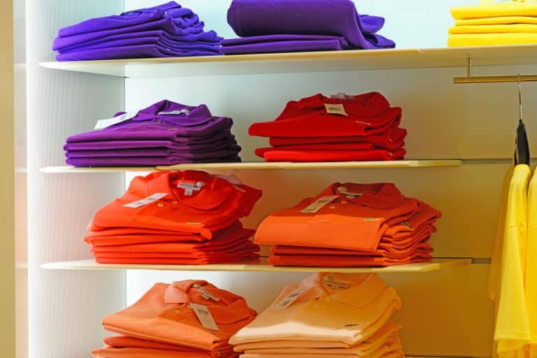 Colorful polo shirts stacked on a shelf in a Lacoste store