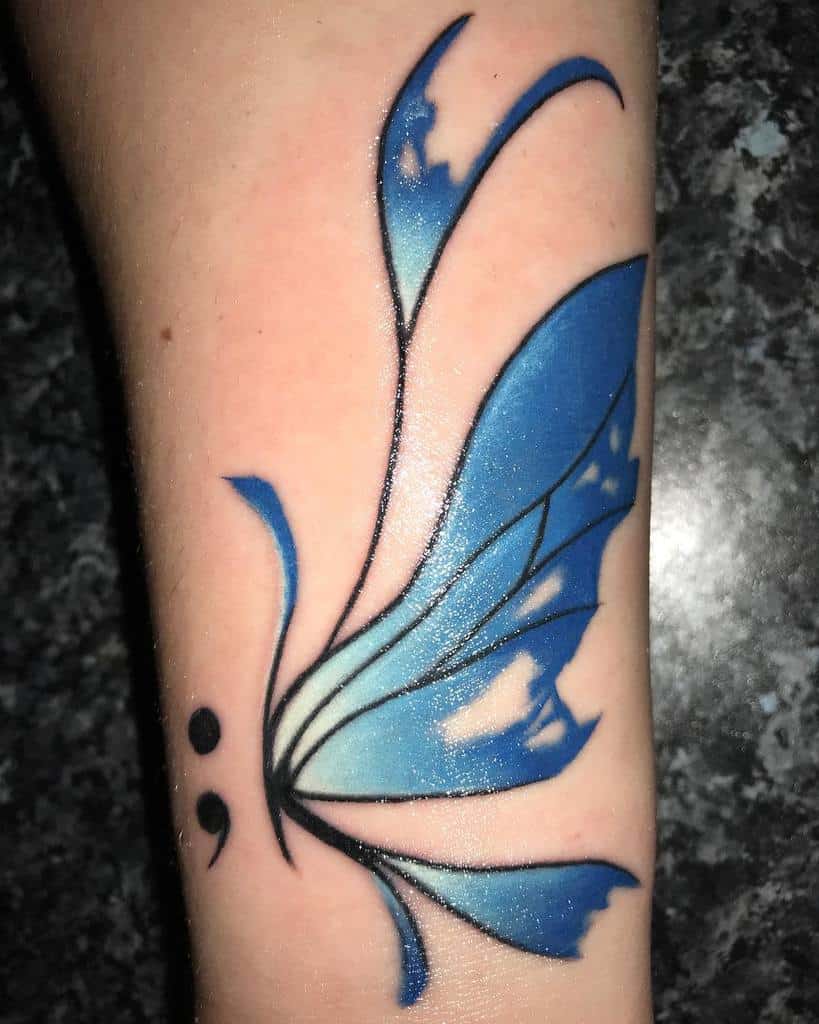 A vibrant blue semicolon butterfly tattoo with abstract wings, symbolizing transformation, mental health awareness, and hope