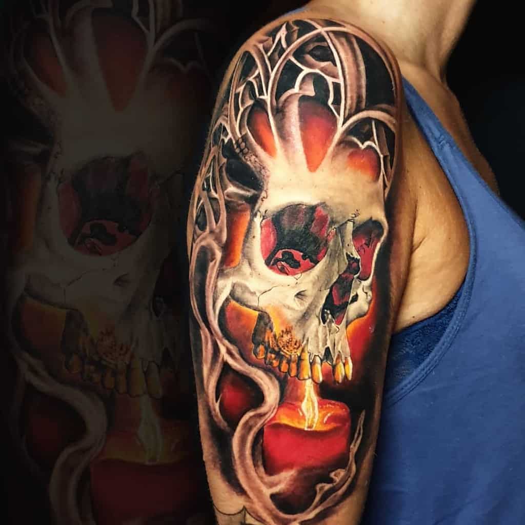 Colorful skull tattoo with candle and abstract patterns on upper arm