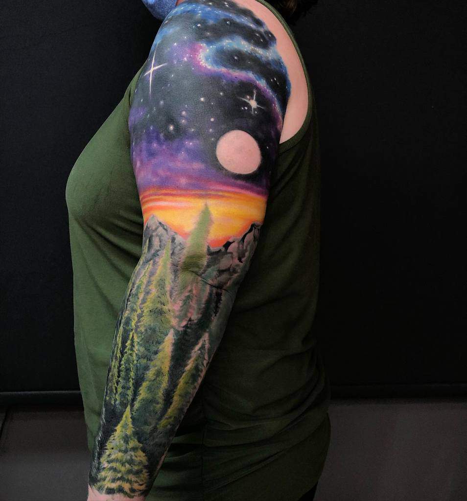 Tattoo sleeve of a forest with a night sky and moon on a woman's arm