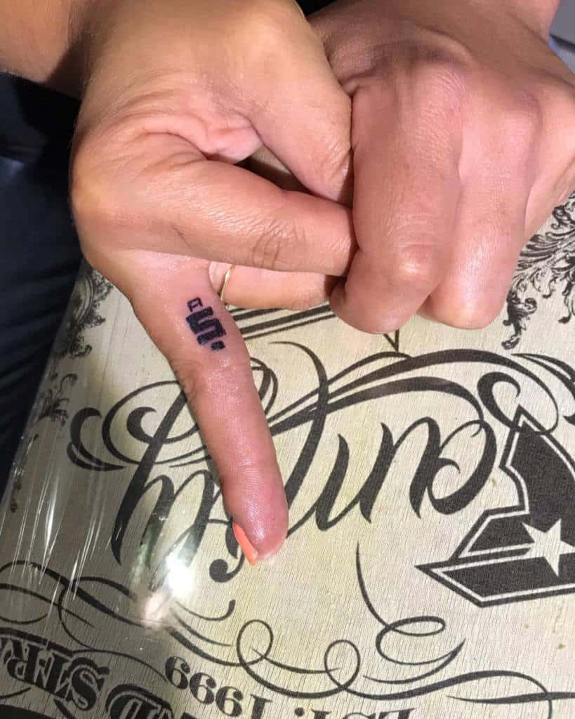 Finger with a small "flip" tattoo pointing upwards