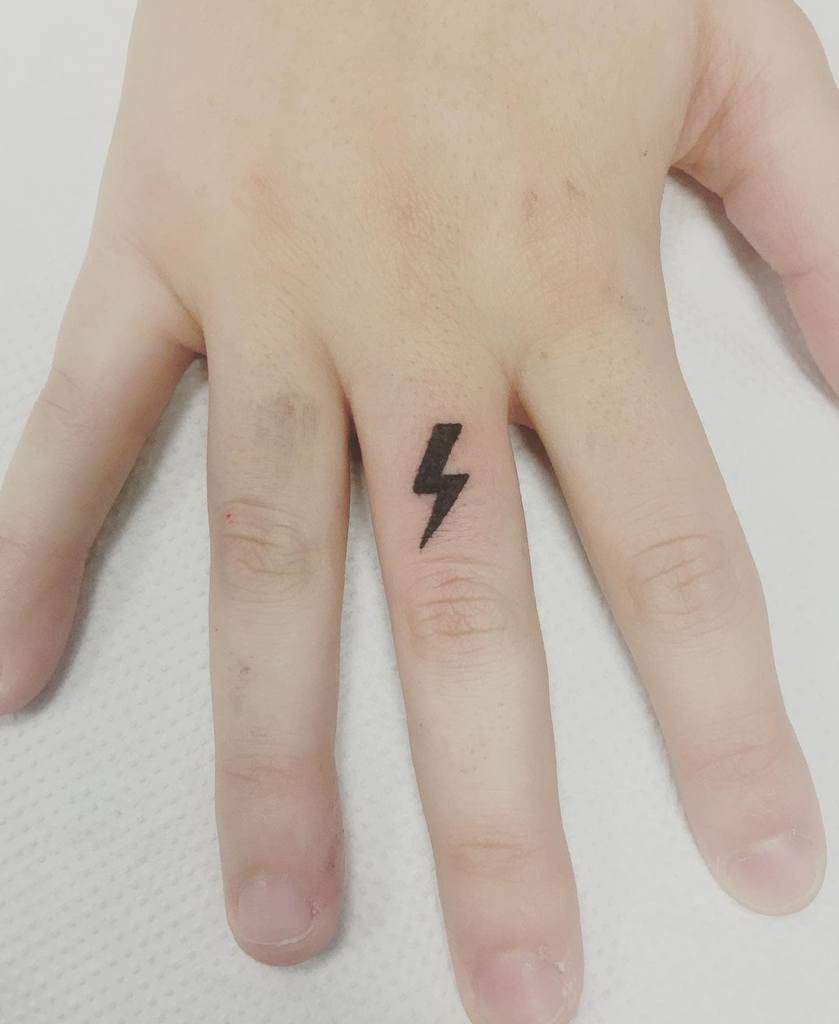 Hand with a lightning bolt tattoo on the middle finger