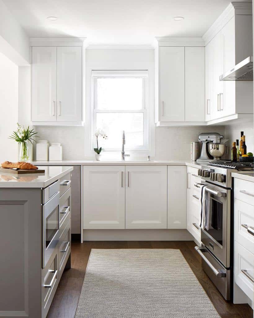 white kitchen cabinets steel appliances gray floor rug