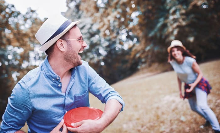 Couple Playing Frisbee In Park