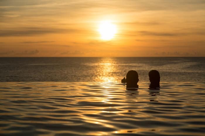 Couple Swimming At Sunset