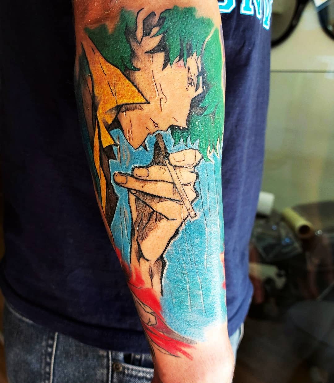 Forearm tattoo of Spike Spiegel from Cowboy Bebop, holding a cigarette with a serious expression, set against a vibrant background