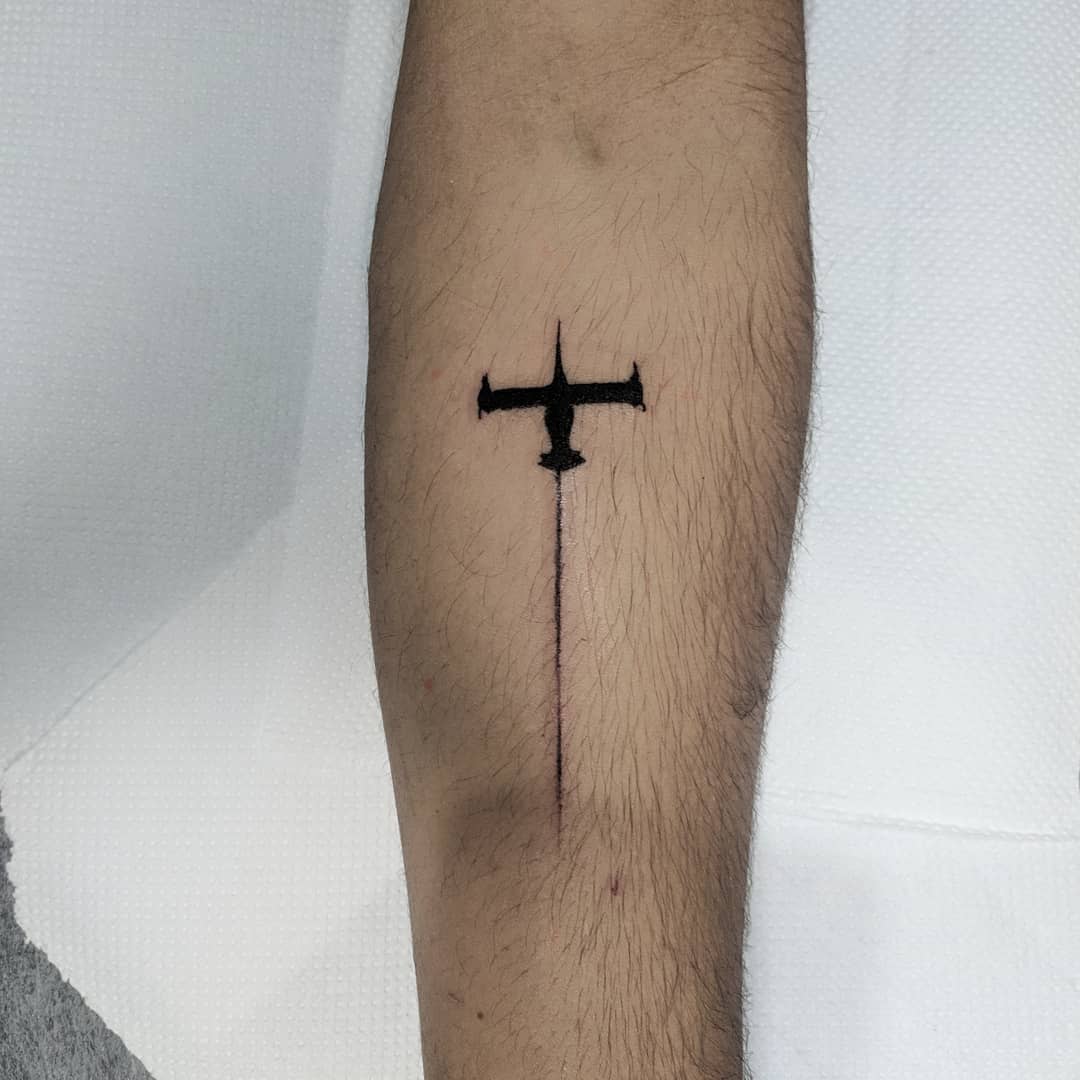 Simple black tattoo of the Swordfish II from Cowboy Bebop, positioned vertically on the forearm