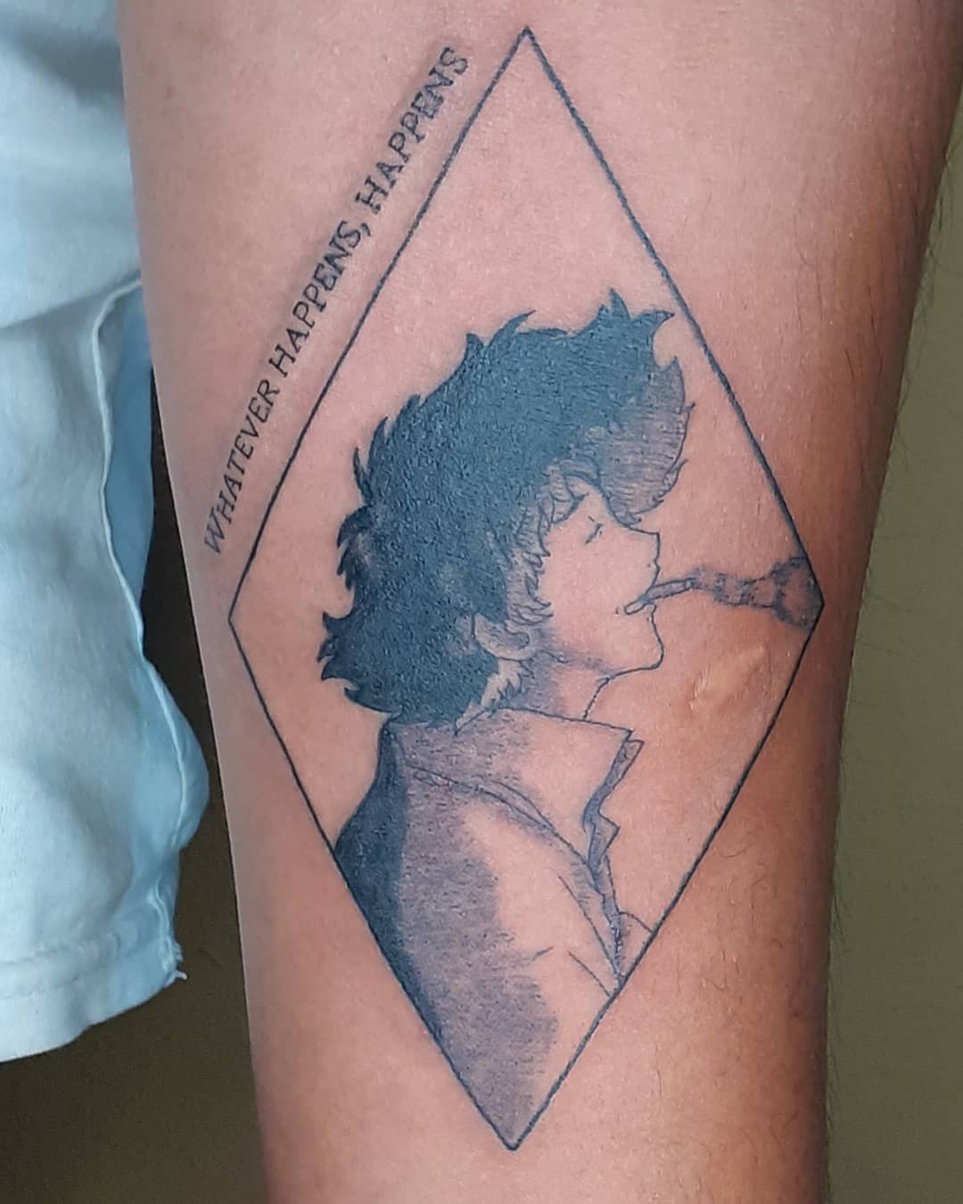 Tattoo of Spike Spiegel from Cowboy Bebop, smoking with a relaxed expression inside a diamond-shaped frame, accompanied by the phrase 'Whatever happens, happens.'