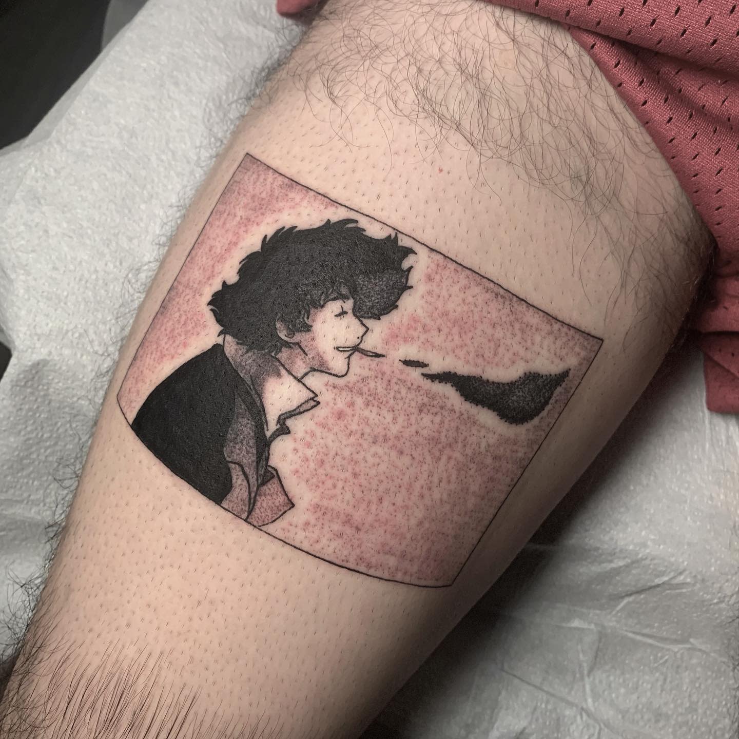 Tattoo of Spike Spiegel from Cowboy Bebop, exhaling smoke with a calm expression, in a rectangular frame