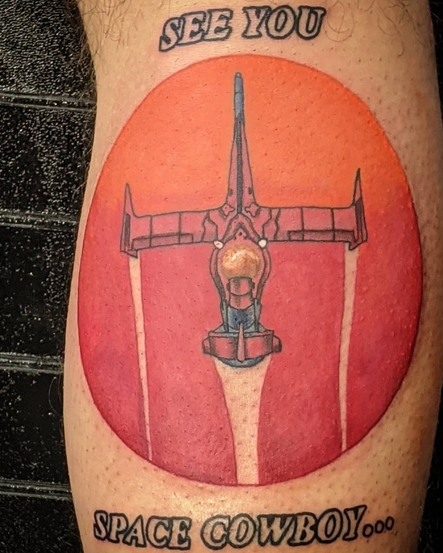 Tattoo of the Swordfish II spaceship from Cowboy Bebop, flying against a red-orange circular background with the text 'See You Space Cowboy...' above and below