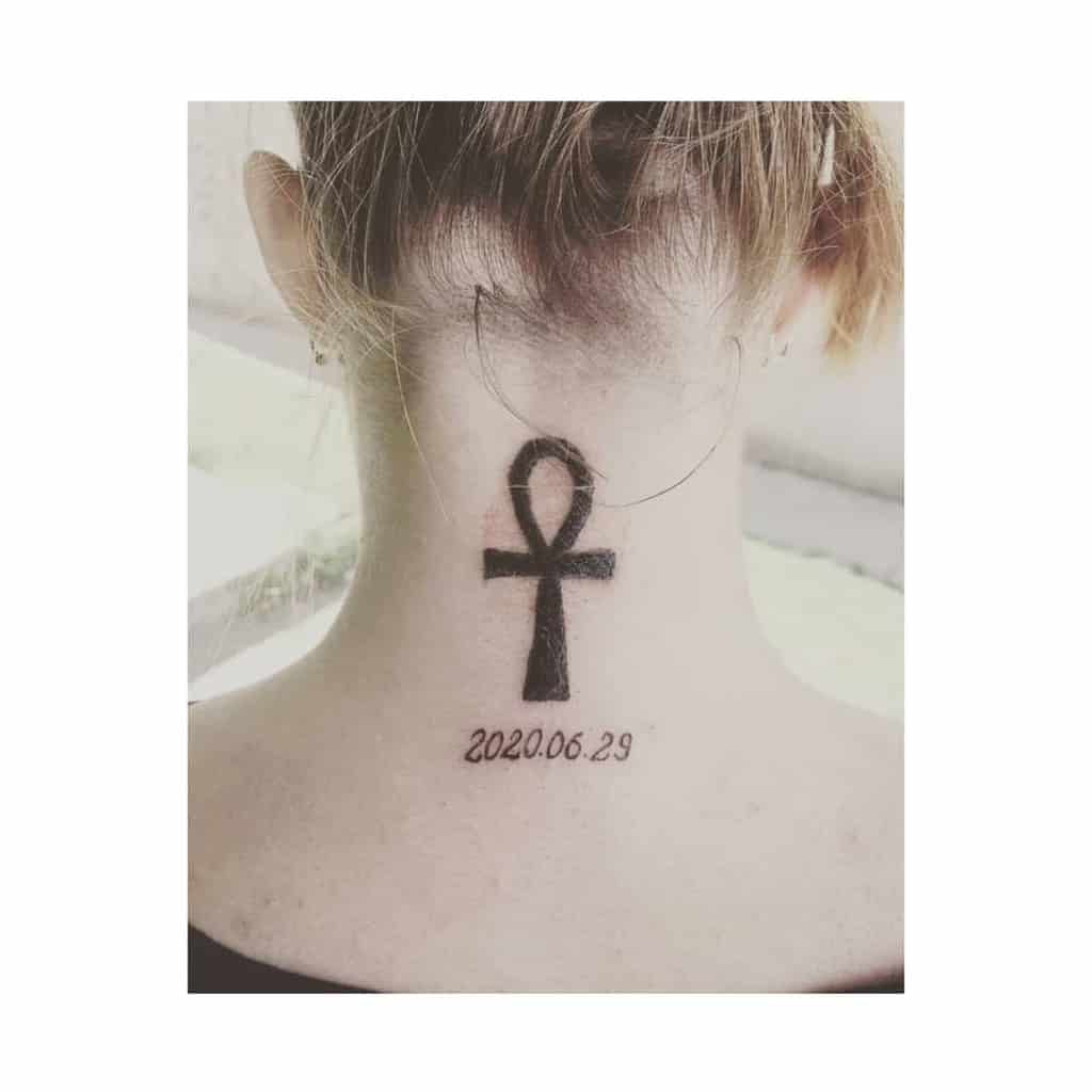 Ankh symbol tattoo with the date 2020.06.29 elegantly placed on the back of neck