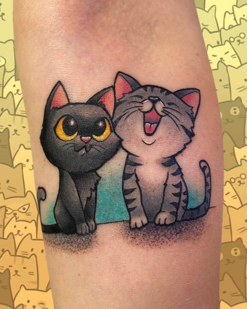 Tattoo of two animated cats, one black and one gray tabby