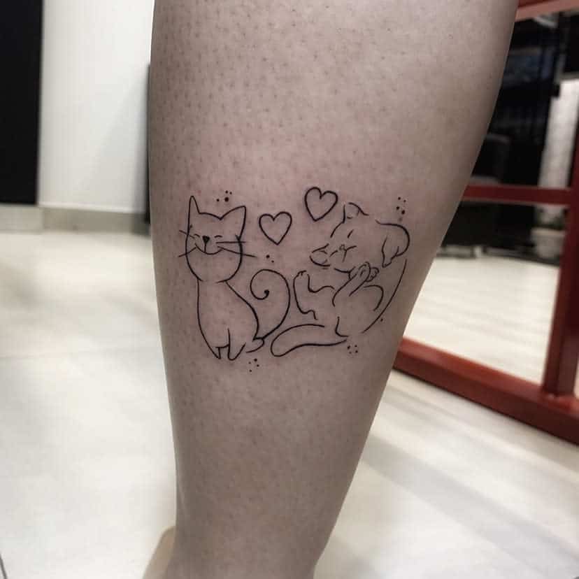 Tattoo of a cat and dog intertwined with hearts on the back of a person's leg