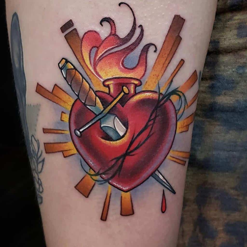 Tattoo depicting a heart with a dagger, flame, barbed wire, and dripping blood