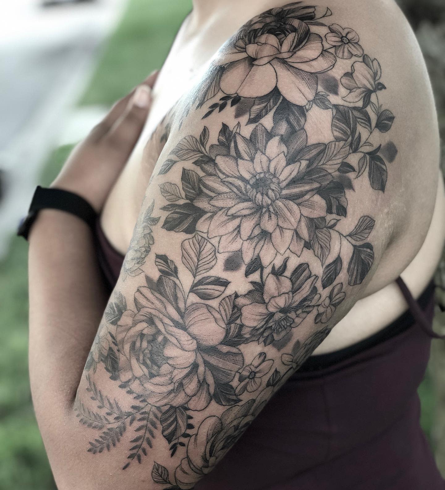 Individual with a detailed floral tattoo sleeve on their upper arm