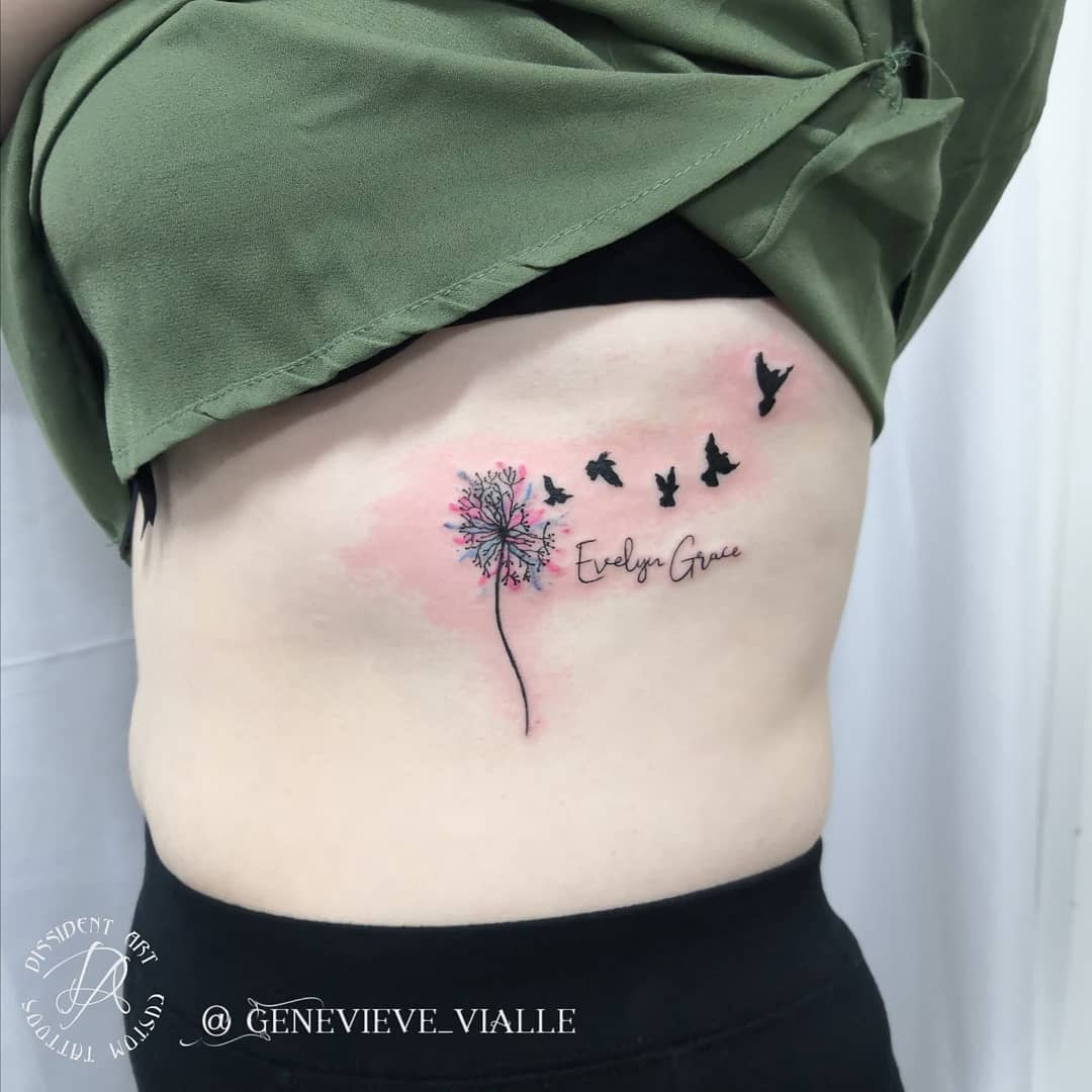 Tattoo of a dandelion turning into birds with the name "Evelyn Grace" written on the side of a torso