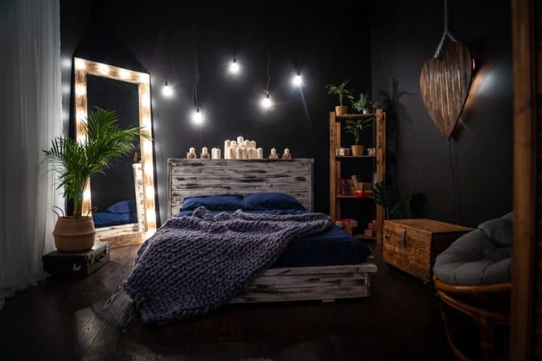 Dark bedroom with large mirror in corner