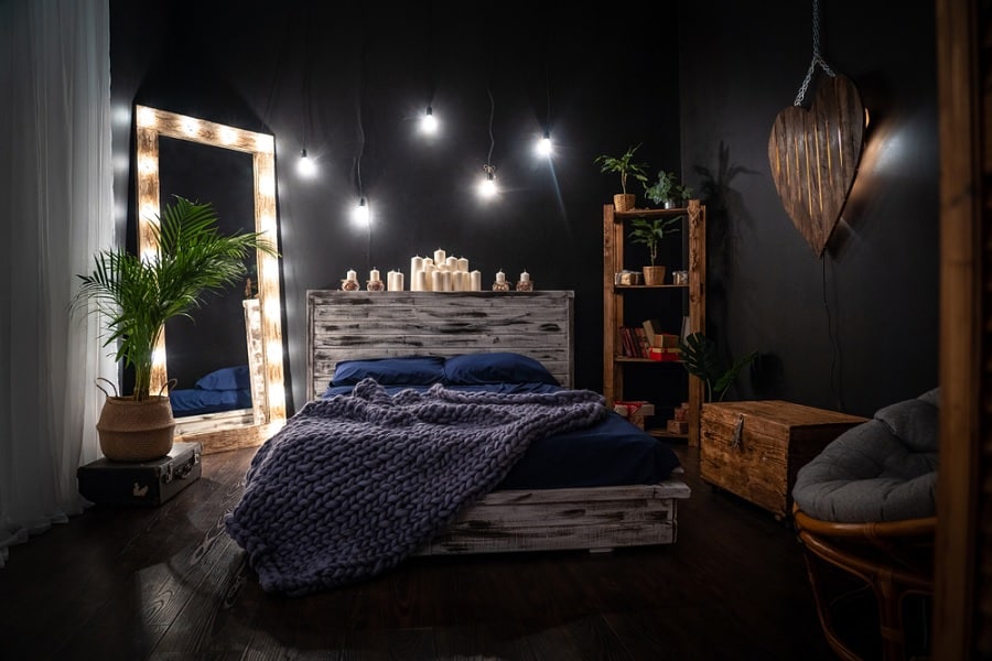 Dark bedroom with large mirror in corner