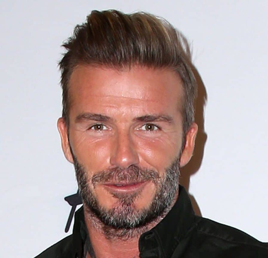 A solo photo of handsome David Beckham wearing a black polo shirt