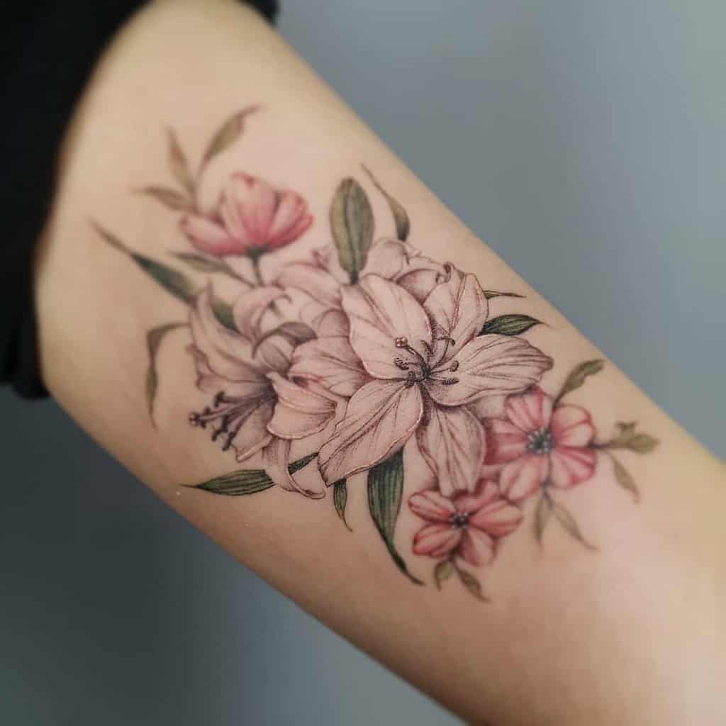 Elegant floral tattoo featuring soft pink lilies and delicate blossoms with fine shading