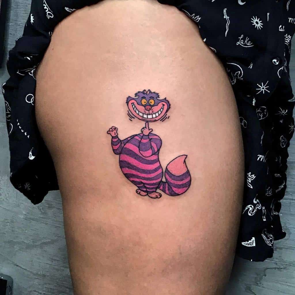 A playful tattoo of the Disney Cheshire Cat with its head floating above its body, featuring pink and purple stripes