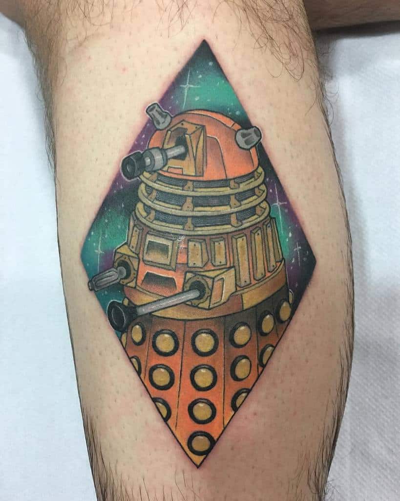 Vibrant tattoo of a Dalek from 'Doctor Who', framed within a diamond shape, set against a cosmic background with stars and nebulae in shades of green and pink