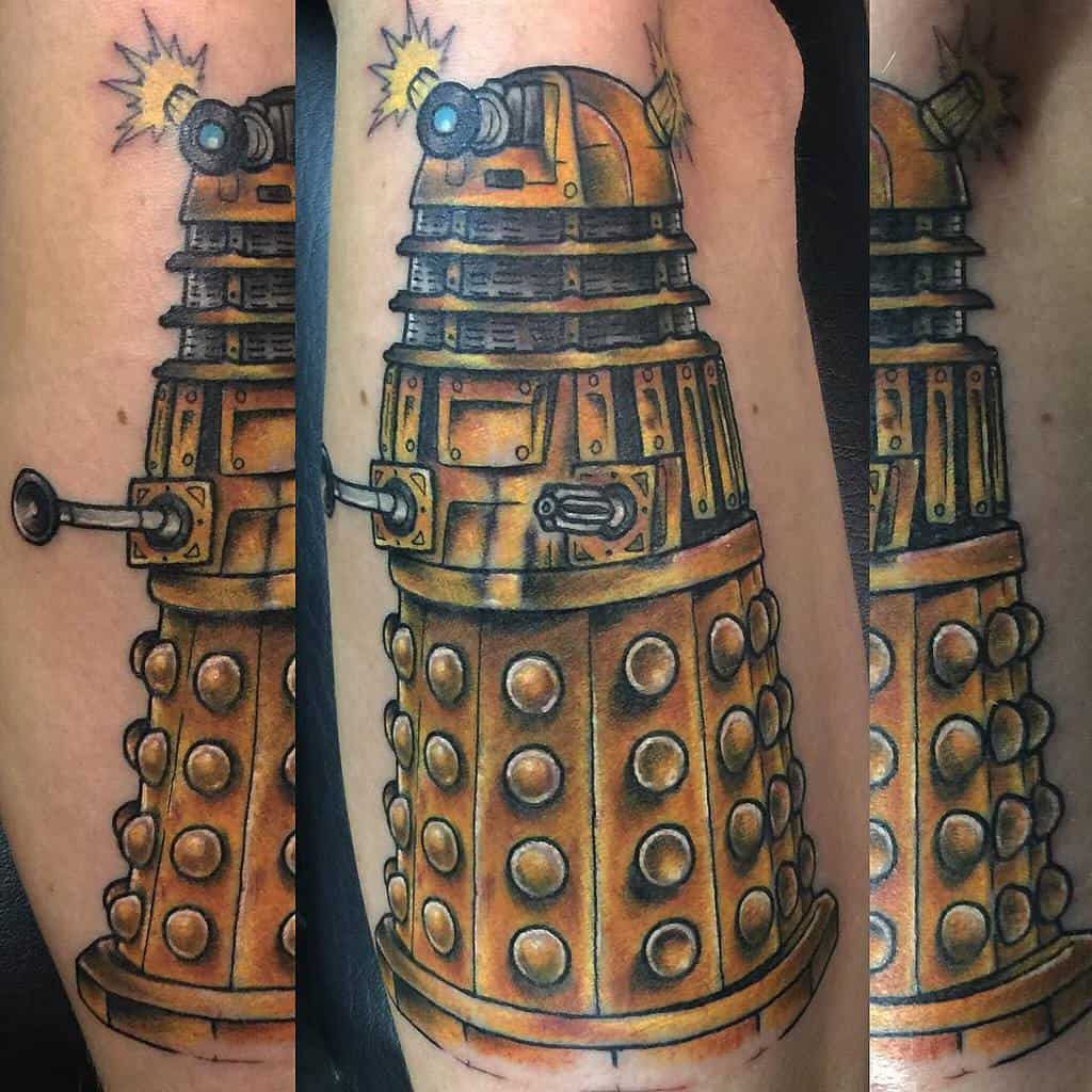 Three-angle view of a detailed tattoo depicting a Dalek from 'Doctor Who', showcasing rich golden tones and intricate textures, with dynamic lighting effects on the eyestalk and gunstick